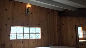 A room with wooden walls, a large window, and a bed. - Persea House. Ideal for families and lovers of Bologna and its peace. (Tarifa)