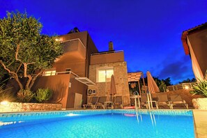 A swimming pool with lounge chairs and a stone building with a window and a door. - Theo Villas With Sea View (Marathokefala)
