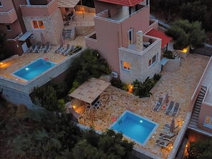 A residential complex with two swimming pools, stone pathways, and outdoor seating areas. - Theo Villas With Sea View (Marathokefala)