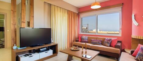 A living room with a flat-screen TV, wooden entertainment unit, sofa, and a dining table.