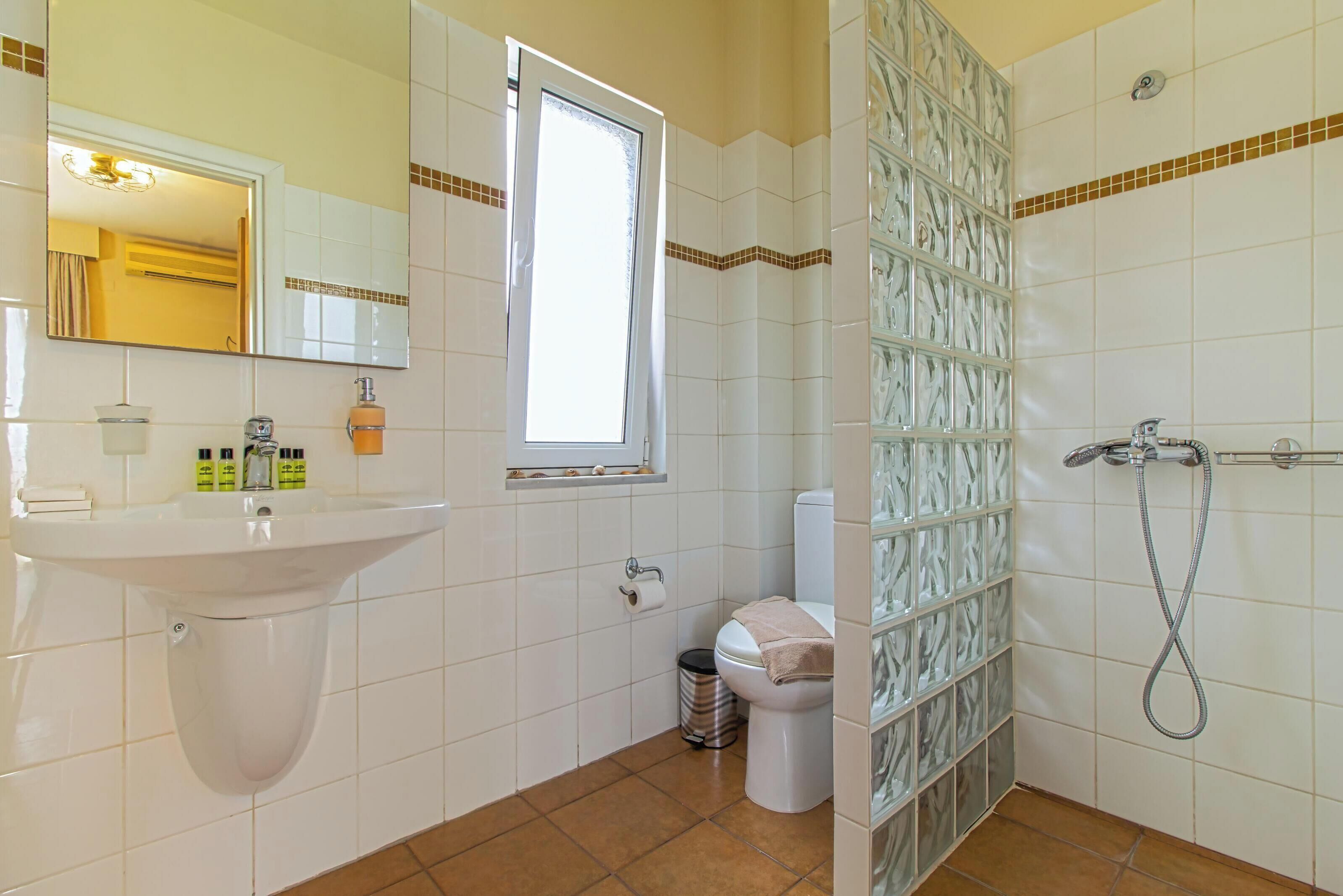 A bathroom with a sink, toilet, and shower.