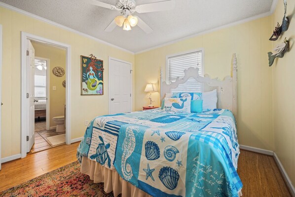 A bedroom with a bed, a door, a window, and a ceiling fan. - Sunrise Shores, Super Easy Beach Access, Great View (Nags Head)