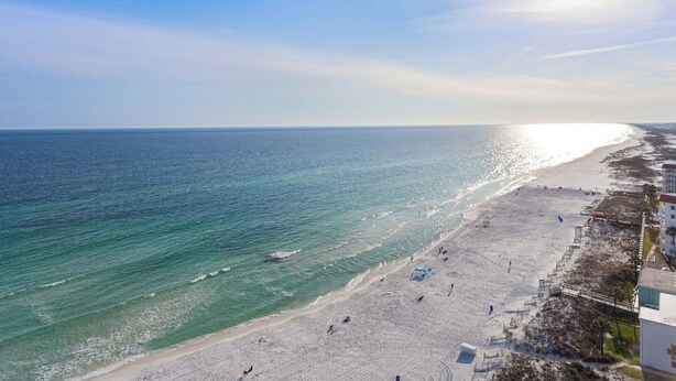 A beach with a clear sky, calm sea, and a few people walking. - The Adventurer’s Micro Studio at Beachview (Fort Walton Beach)