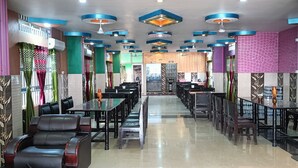 A spacious restaurant with high ceilings, modern lighting, and a central walkway. - Hotel Sunjukti by Roh (Nagaon)