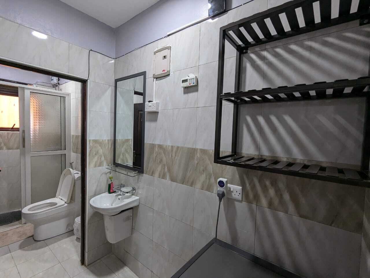 Ein Badezimmer mit Toilette, Waschbecken, Spiegel und Handtuchhalter.
