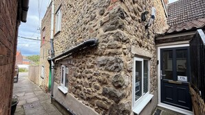 A narrow street with a stone building, a black door labeled "11b Market Place," and a small window. - The Market Hideaway - Bedale town centre (Bedale)
