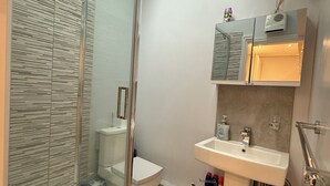 A modern bathroom with a glass shower enclosure, a white sink, and a toilet. - The Market Hideaway - Bedale town centre (Bedale)