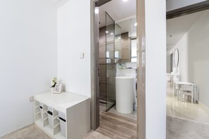 A modern bathroom with a white vanity, a glass shower enclosure, and a white sink. - Waterfront 3BR with Marina View at DEC (Dubai)