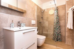 Regadera, secadora de cabello, toallas, papel de baño 