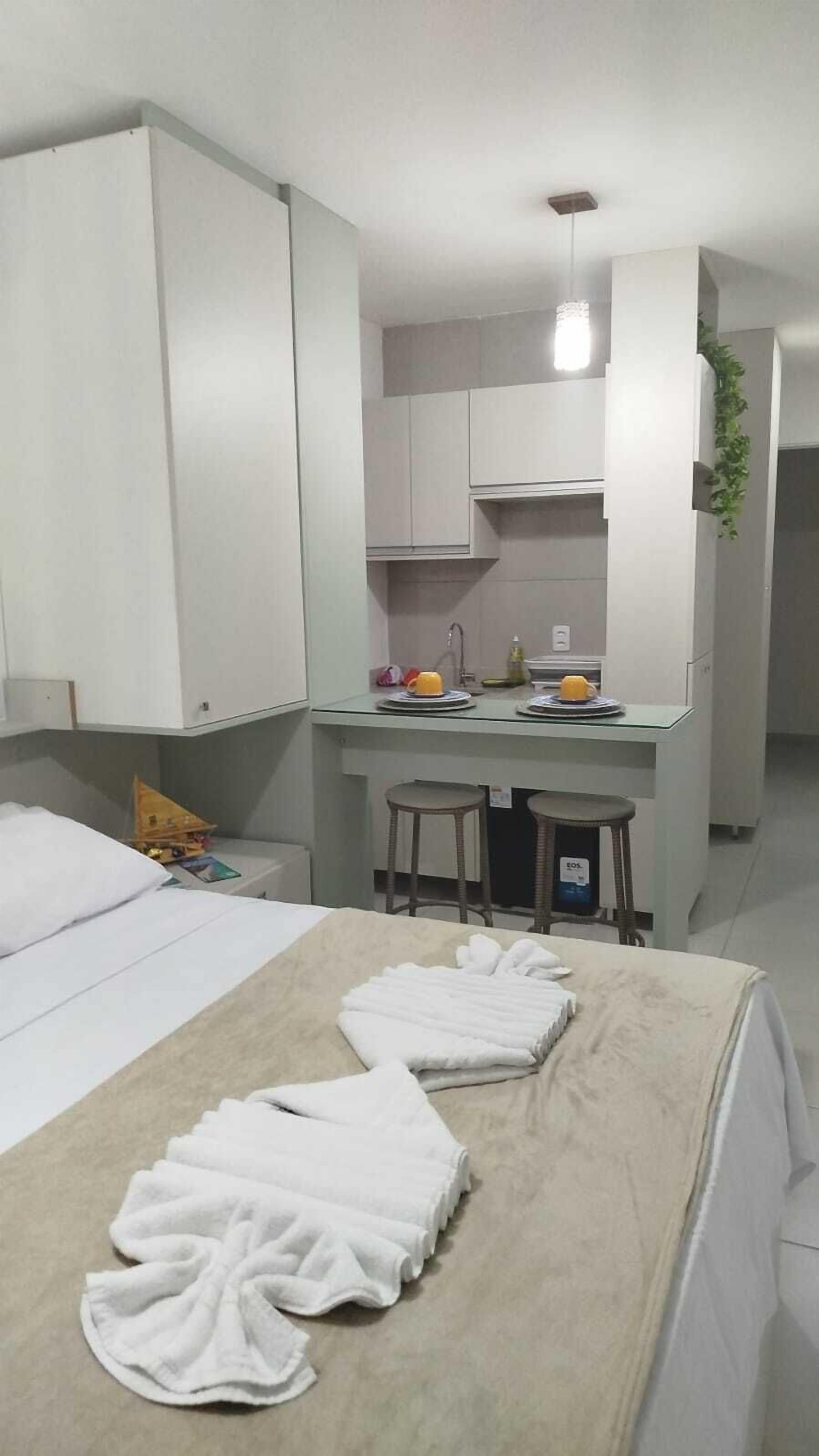 Una camera d'albergo con un letto, un angolo cottura e un bagno.