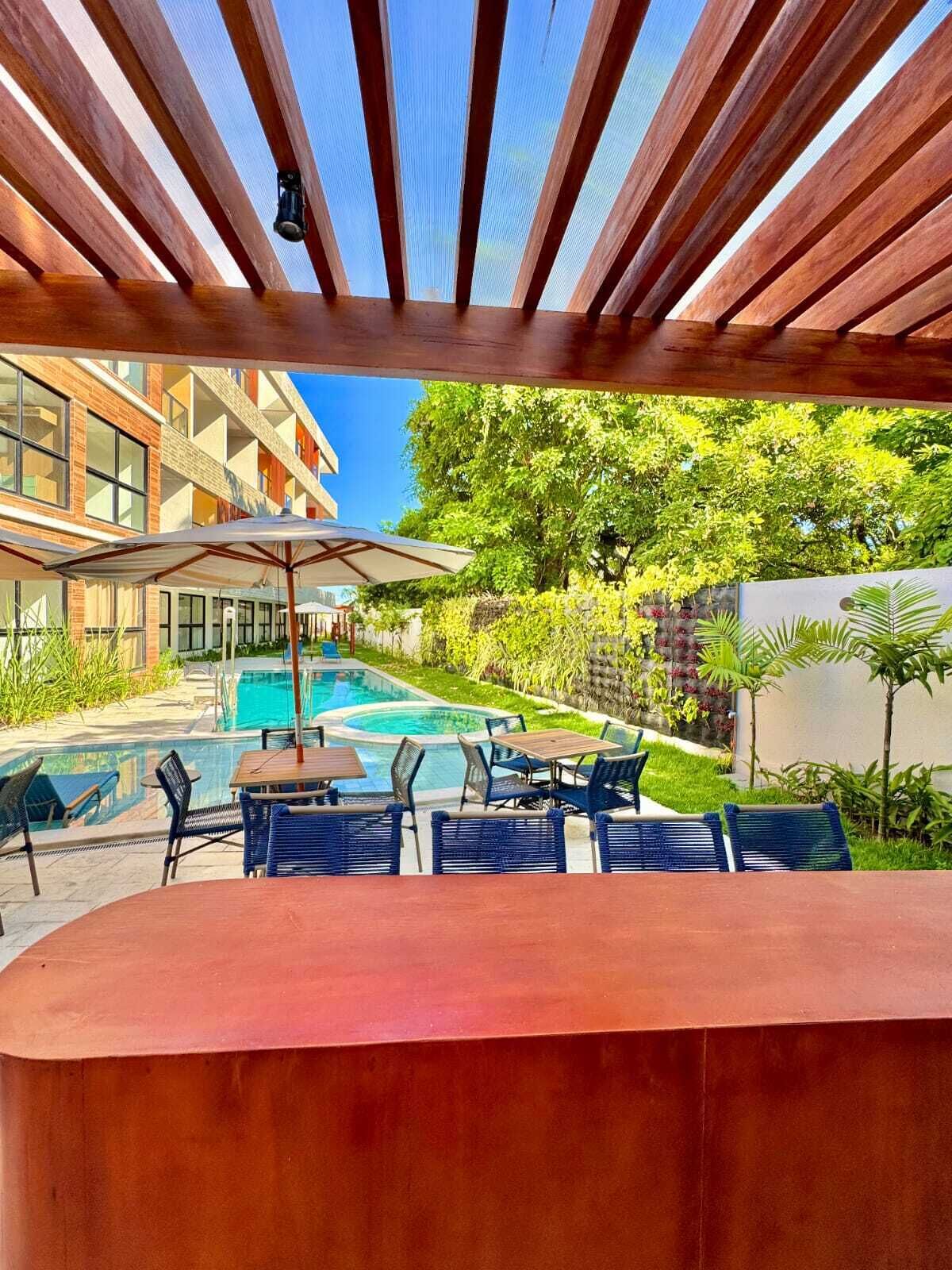 A poolside area with outdoor seating and a view of a building in the background.