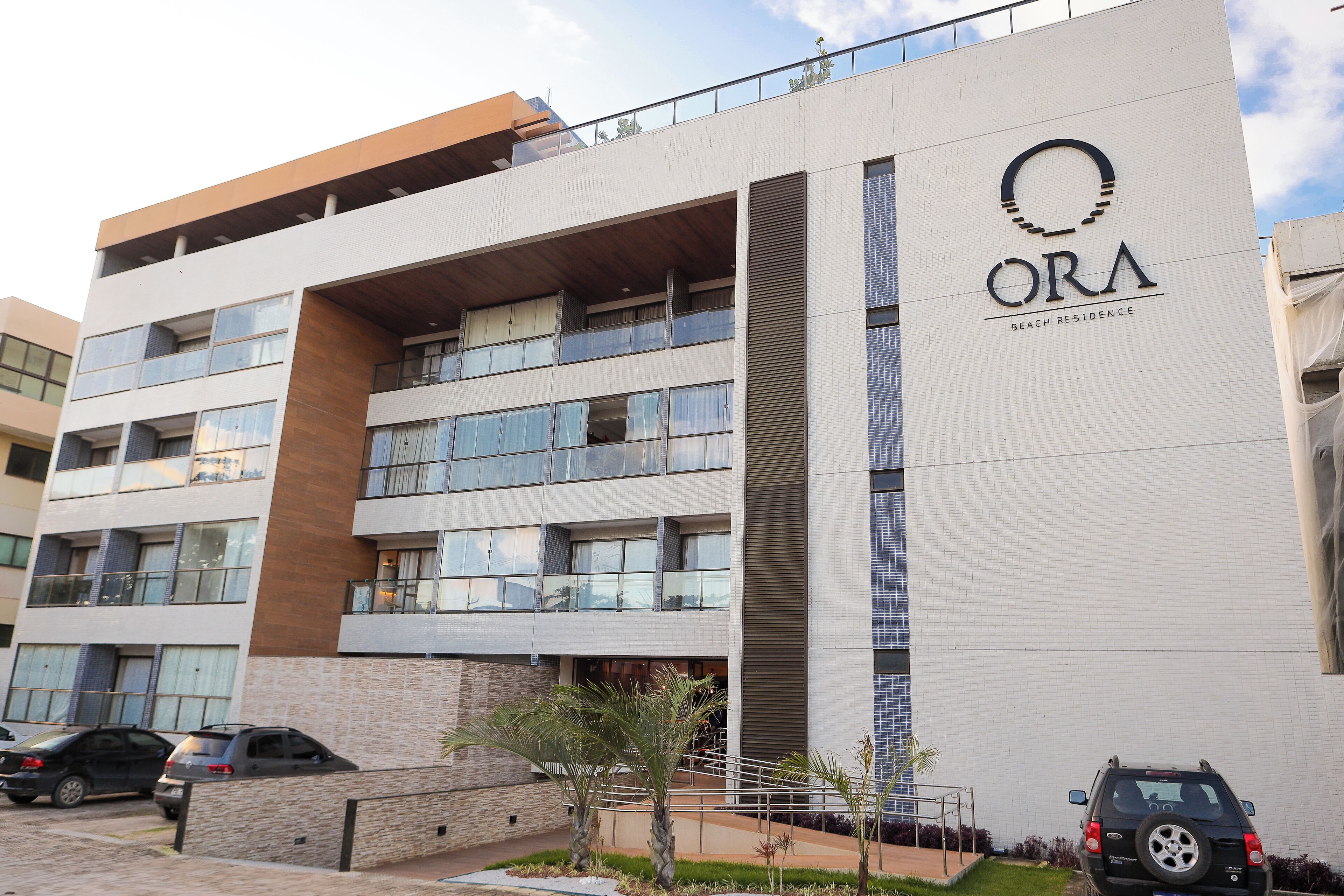 Un edificio de varios pisos con un cartel que dice 'ORA BEACH RESIDENCE'.