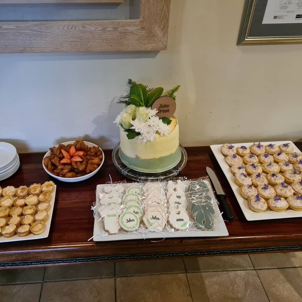 A dessert table with a cake, cookies, and pastries.