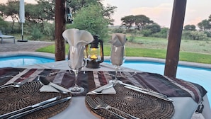A dining table set with a placemat, tableware, and a lantern. - Mattanu Private Game Reserve (Dikgatlong)