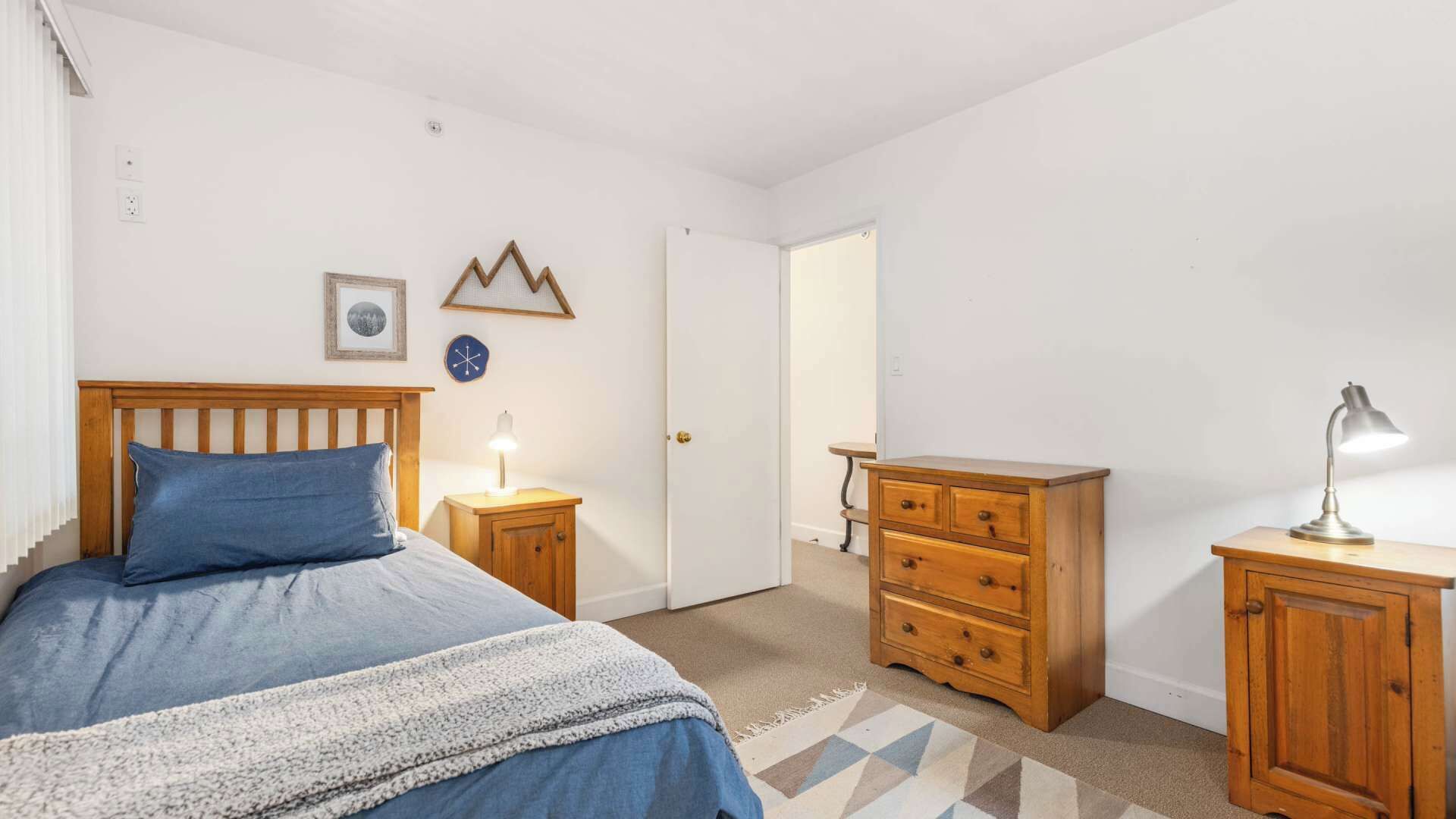 Ein Schlafzimmer mit einem Bett, Nachttischen, einem Schminktisch und einer Lampe.