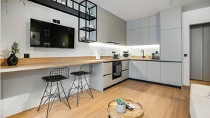Eine moderne Küche mit einer Holzausziehtafel, integrierten Geräten und einem schwarzen Metallstuhl.