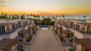 A resort with a central pool, multiple buildings, and a sunset view. - Royal Apartment (Michamvi)