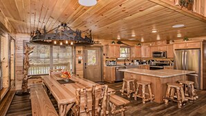 Une cuisine spacieuse dotée de meubles en bois, d’un îlot central avec des tabourets et d’un grand réfrigérateur.