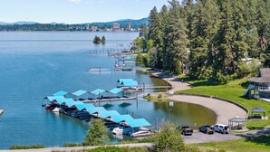 A marina with docked boats, a parking area, and a gazebo. - Rustic A-Frame Cabin | Dock | Paddleboards | Summer Camp Vibes (Coeur D'Alene)