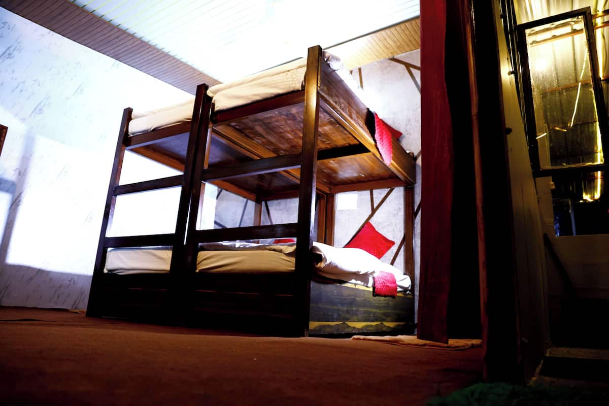 Uma cama beliche com estrutura de madeira e colchão.