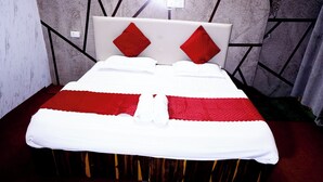 A bed with a white and red bedspread, a wooden headboard, and red pillows. - The Escapee Resort (Dhanaulti)