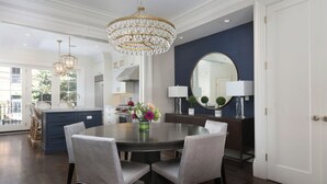 A dining area with a round table, four chairs, a chandelier, and a large mirror. - Renovated Boston Brownstone in Sought After Location! (Boston)