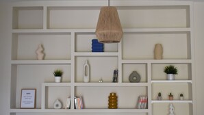 A modern interior with white shelves displaying various decorative items and a hanging pendant light. - Downtown Apartment with Parking and Terrace (Córdoba)