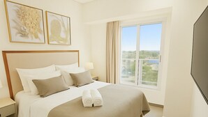 A hotel room with a large bed, a TV, and a window with a view. - Residence del Maestro Apartments (Asunción)