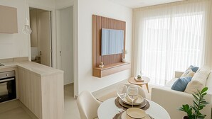 A modern living space with a dining area, a sofa, and a kitchen. - Residence del Maestro Apartments (Asunción)