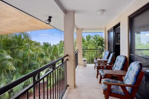 A balcony with a view of greenery, a railing, and several chairs. - 5BR Coastal Escape, Walk to Peregian Beach! (Peregian Beach)