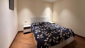 A bedroom with a bed, bedside tables, and a nightstand.