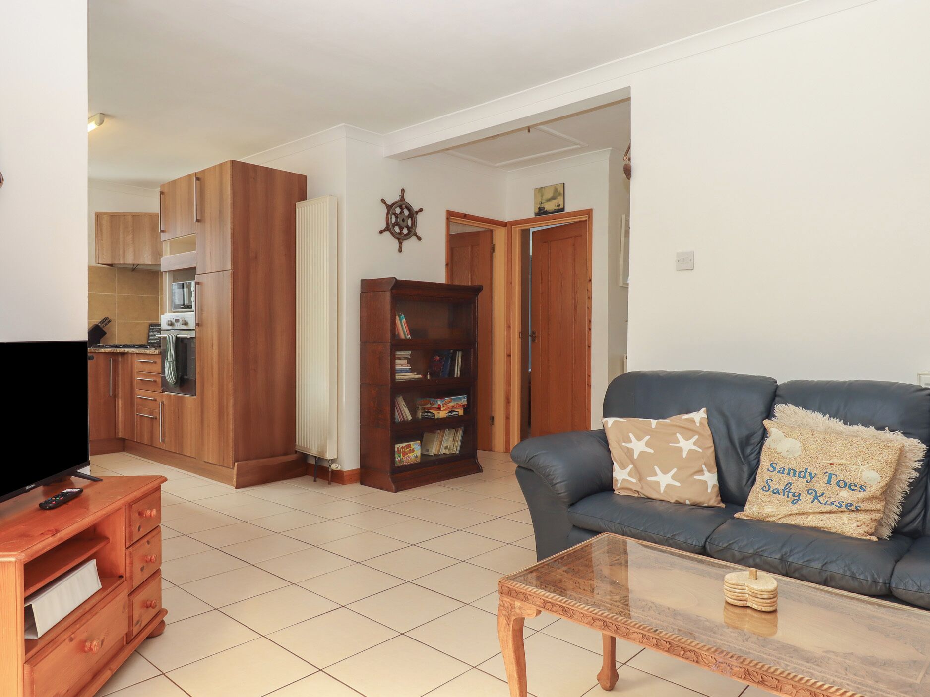 A living room with a blue sofa, wooden coffee table, and a bookshelf.