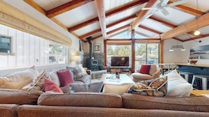 A cozy living room with a large sofa, a fireplace, and a television.