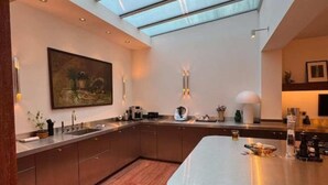 Una cocina moderna con tragaluz, armarios de madera y una isla central.