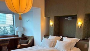Un dormitorio con una cama grande, un escritorio y una silla.