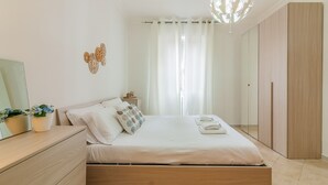 Een moderne slaapkamer met een houten bed, een nachtkastje met een lamp en een kledingkast.