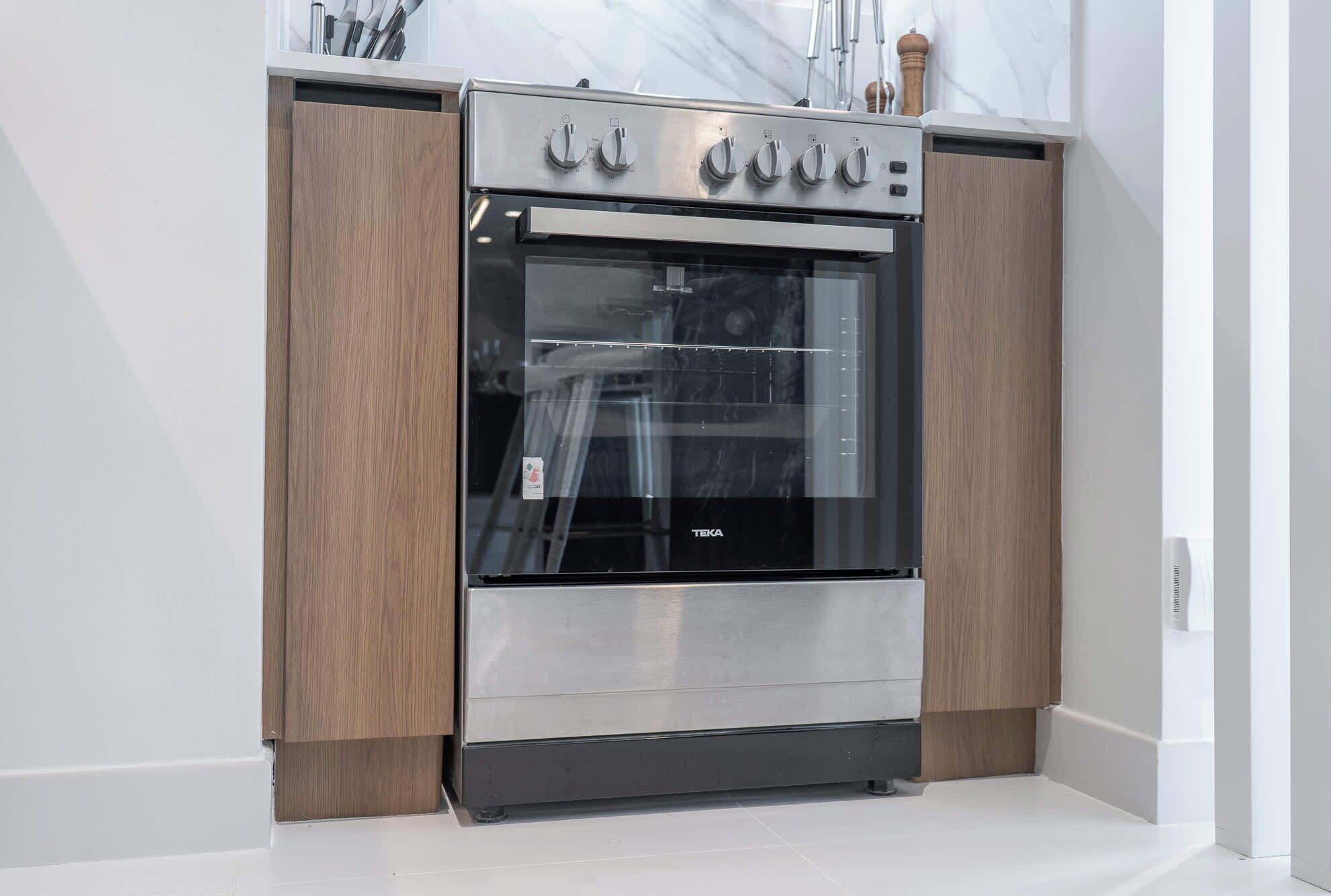 Una cocina moderna con horno de acero inoxidable integrado y armarios de madera.