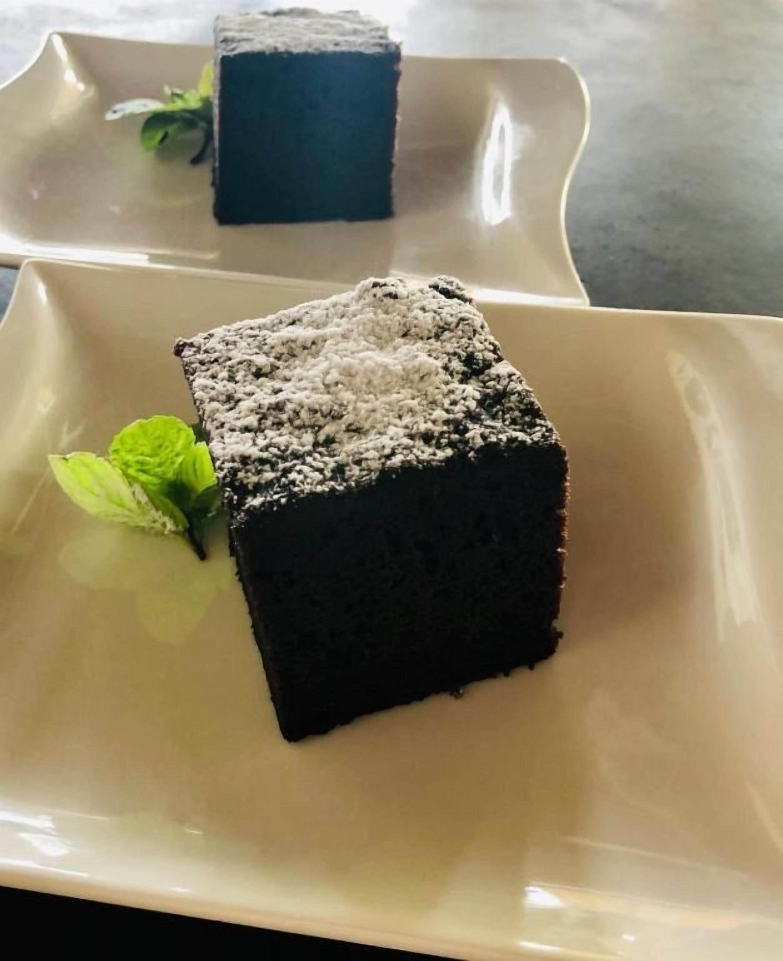 Un postre sobre un plato color beige, adornado con una ramita de menta.