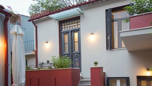A building with a red exterior, a double door, and a staircase leading to the entrance. - Vol3 (Athens)