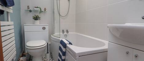A bathroom with a toilet, a bathtub, and a sink.