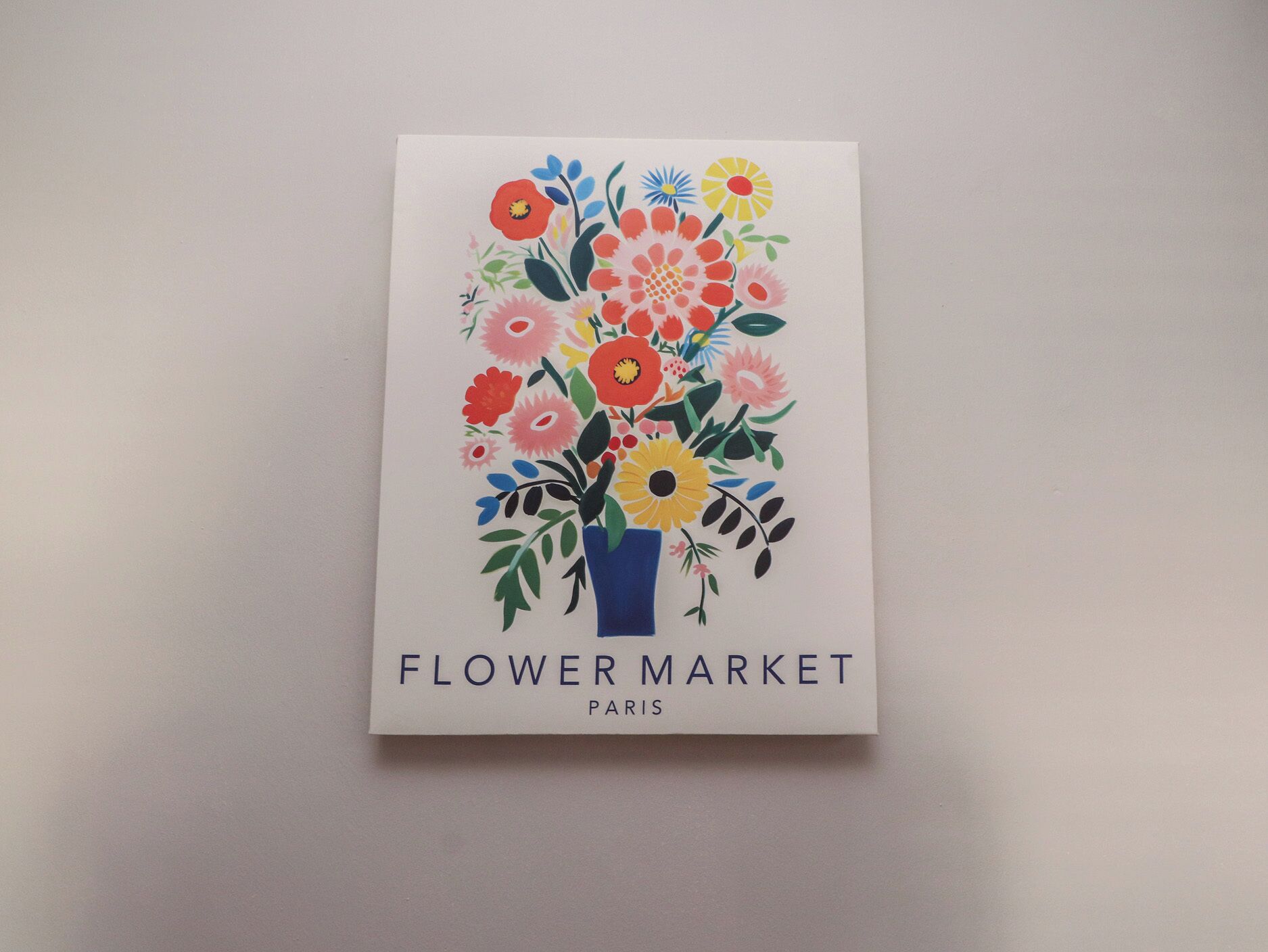 Een witte kaart met een kleurrijk bloemenpatroon en de tekst 'Flower Market Paris'.