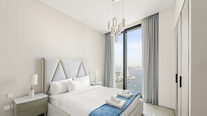 Une chambre d’hôtel moderne avec un grand lit, une table de chevet, une lampe et une vue sur la ville.