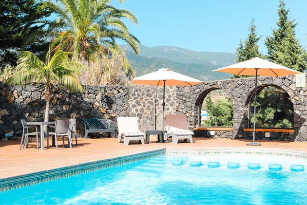 Piscina a l'aire lliure, para-sols i gandules