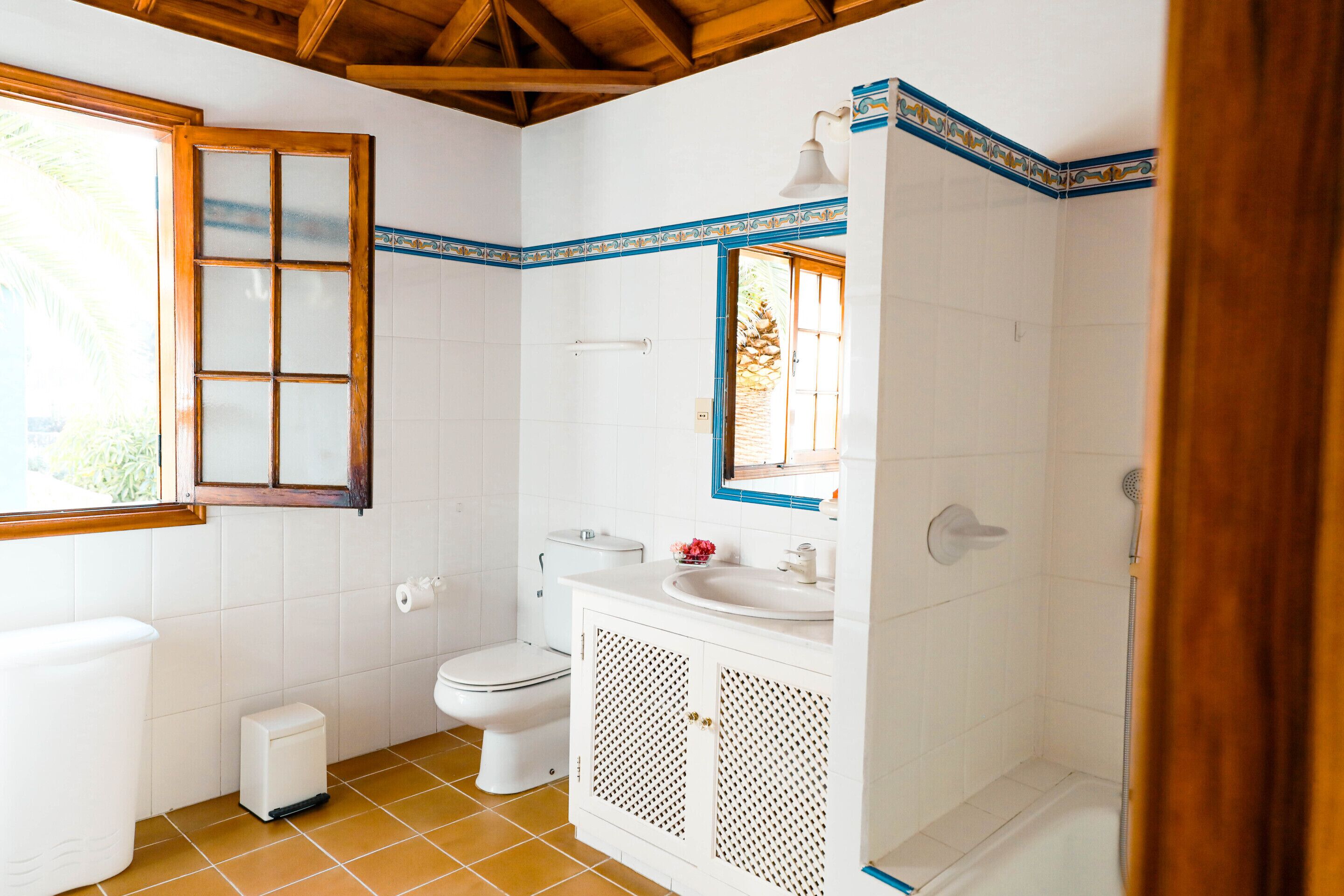 Une salle de bain équipée de toilettes, d’un lavabo, d’une douche et d’une fenêtre.