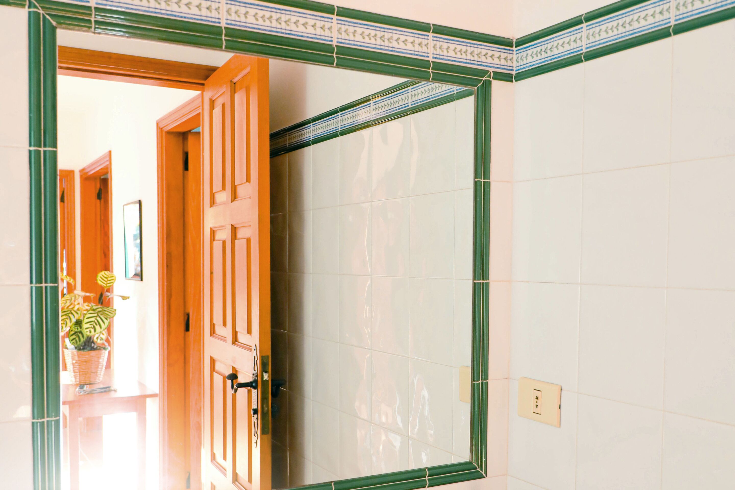 Una habitación con puerta de madera, pared de azulejos y un enchufe a la vista.