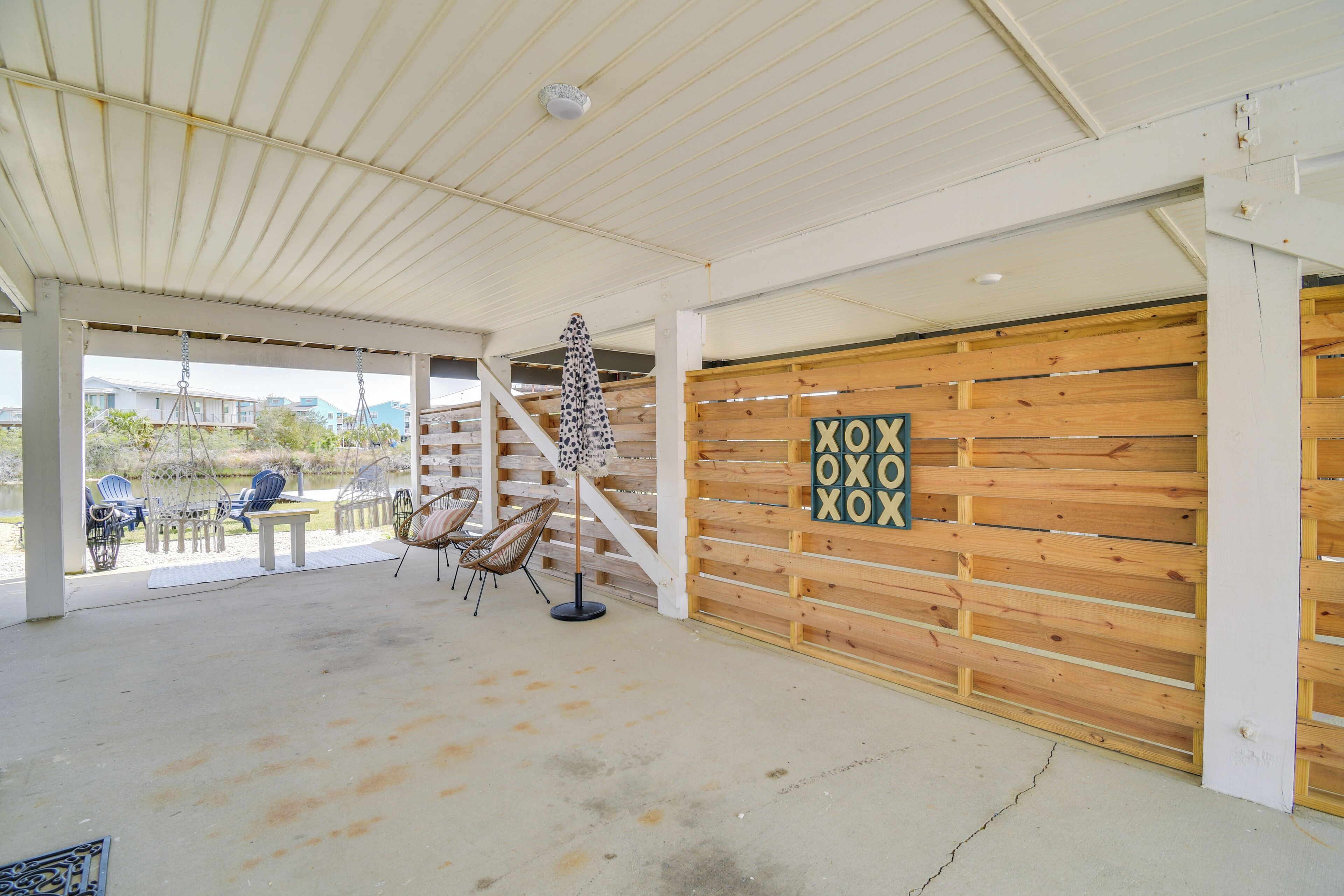 A covered outdoor area with a wooden wall and a sign that reads "XOXO".
