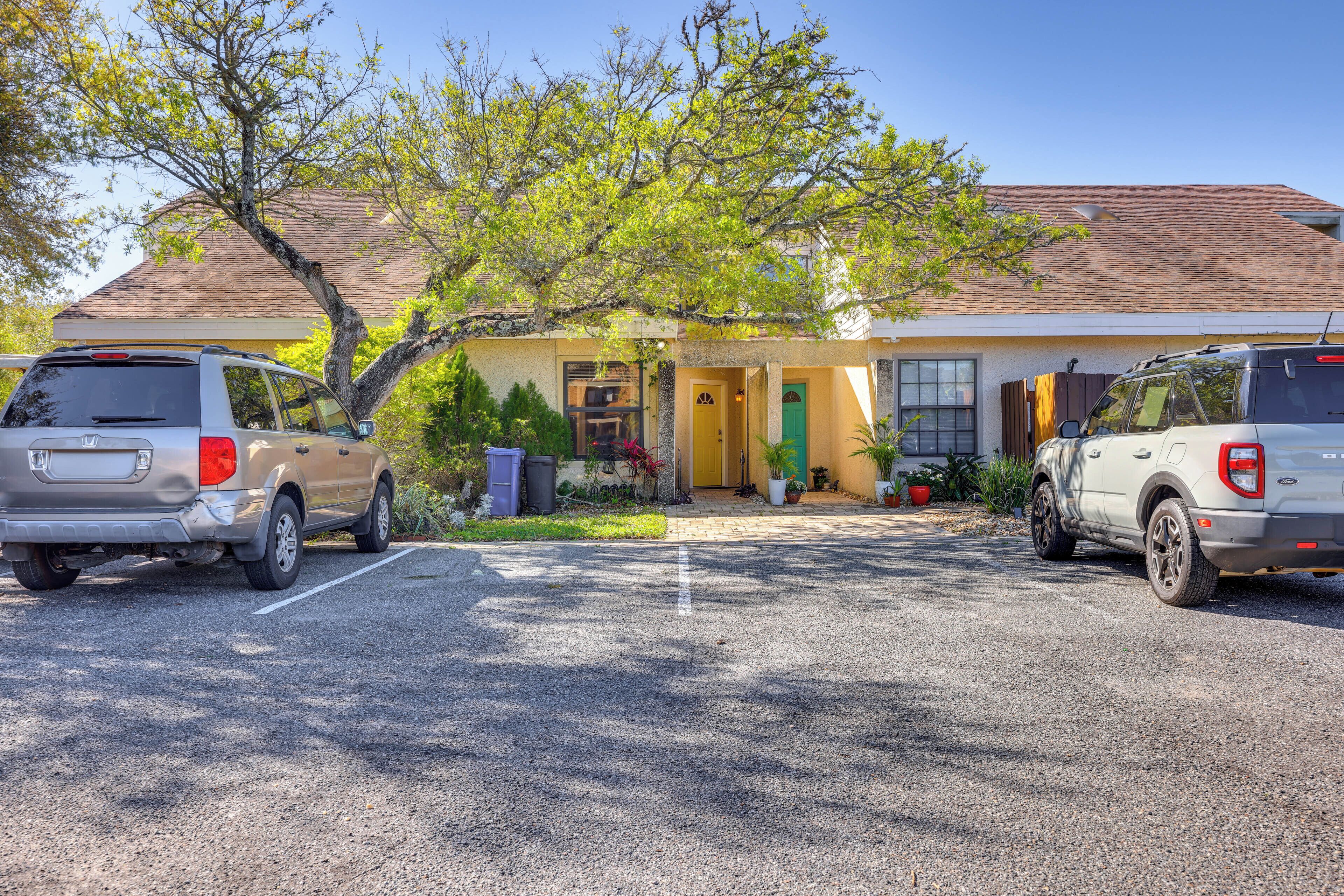 A two-story building with a parking lot. There are two cars parked in the lot.