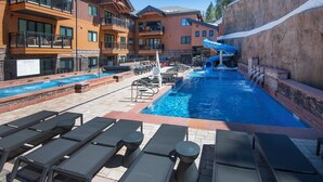 A hotel pool area with lounge chairs, a water slide, and a sign indicating no lifeguard on duty. - New Mtn Modern with Luxurious Amenities | F213 (Avon)
