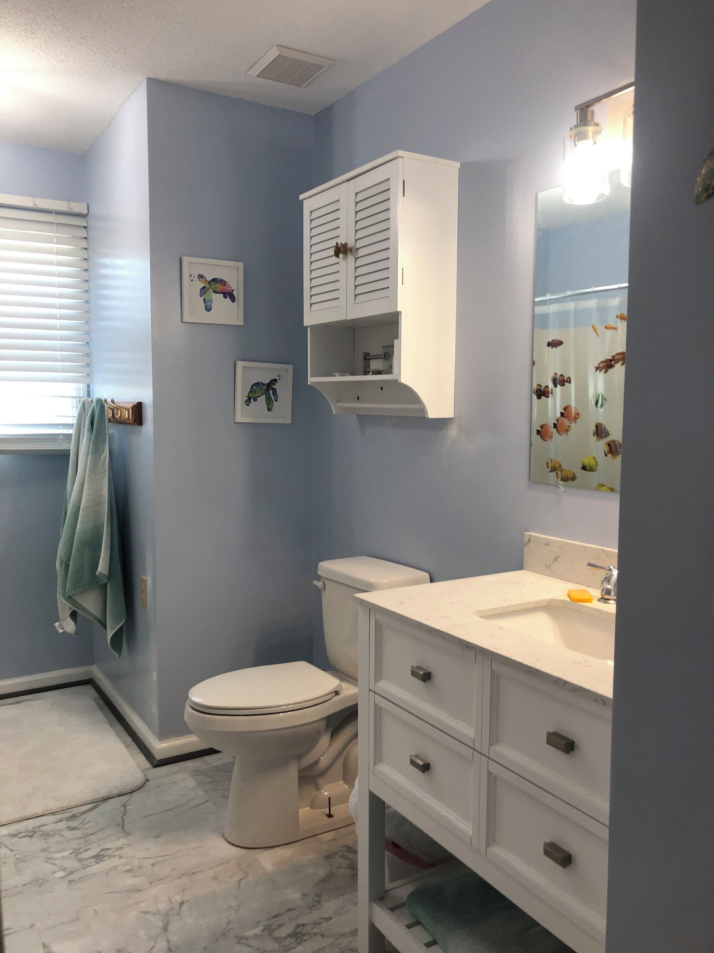 Une salle de bain avec des toilettes, un lavabo et un meuble de rangement.