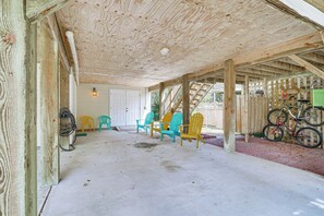 A covered outdoor area with wooden beams, a concrete floor, and colorful Adirondack chairs. - Walk to Beach & Boat Ramp: Home w/ Outdoor Area (Kill Devil Hills)